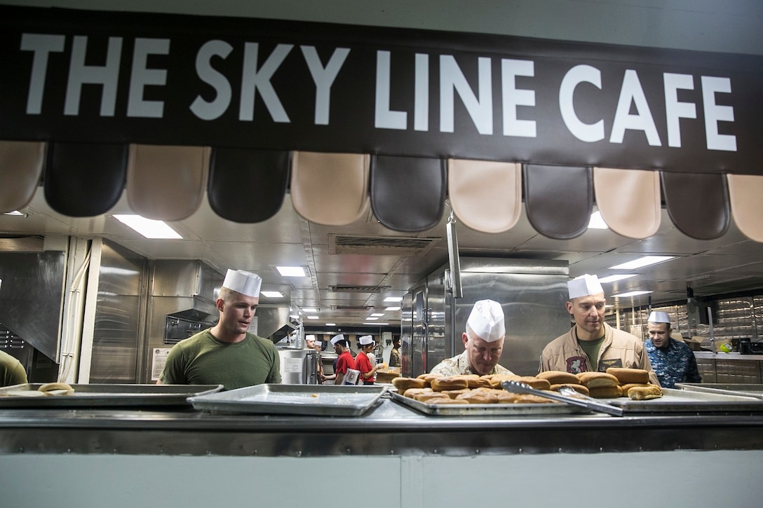 U.S. Marines aboard the USS Essex (LHD 2) serve lunch at sea in the Strait of Malacca, June 15, 2015. The Marines and Sailors aboard the Essex enjoyed a “Steel Beach” day, which consisted of grilling, music, and playing games in the hangar bay and on the flight deck. (U.S. Marine Corps photo by Cpl. Anna Albrecht/Released)