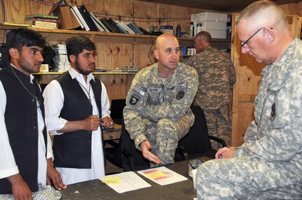 Abdul Wali and Said Obaidullah, Afghan agricultural professionals who are
part of the internship program initiated by the Iowa National Guard's 734th
Agribusiness Development Team, talk about an upcoming field day March 19,
2011, with Army 1st Lt. Scott Shirk, ADT project manager for the Chowkay
District, and Air Force Chief Master Sgt. Don Kuehl, ADT project manager for
the Sarkani District