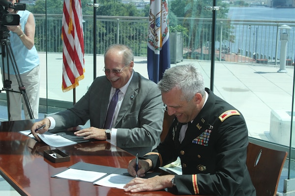 John Reinhart, CEO and executive director of the Virginia Port Authority and Colonel Paul Olsen, Norfolk District, U.S. Army Corps of Engineer's former commander, sign the feasibility cost-share agreement, which commits each side to sharing the cost of evaluating the benefits of two dredging projects critical to the future of Norfolk Harbor.