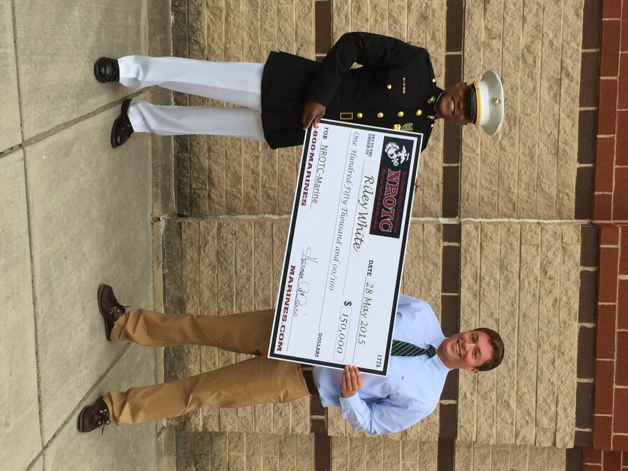 Riley White, right, a Stafford, Virginia native and Colonial Forge High School senior, receives a $150,000 Naval Reserve Officers Training Corps Marine Option Scholarship during a high school awards ceremony at Colonial Forge High School, May 28, 2015. U.S. Marine Corps Capt. Herman Davis, executive officer of Marine Corps Recruiting Station Frederick presented White with the scholarship, which will cover the cost of tuition, books, and a small living stipend. White was also valedictorian of his class, and he will be attending University of Virginia.