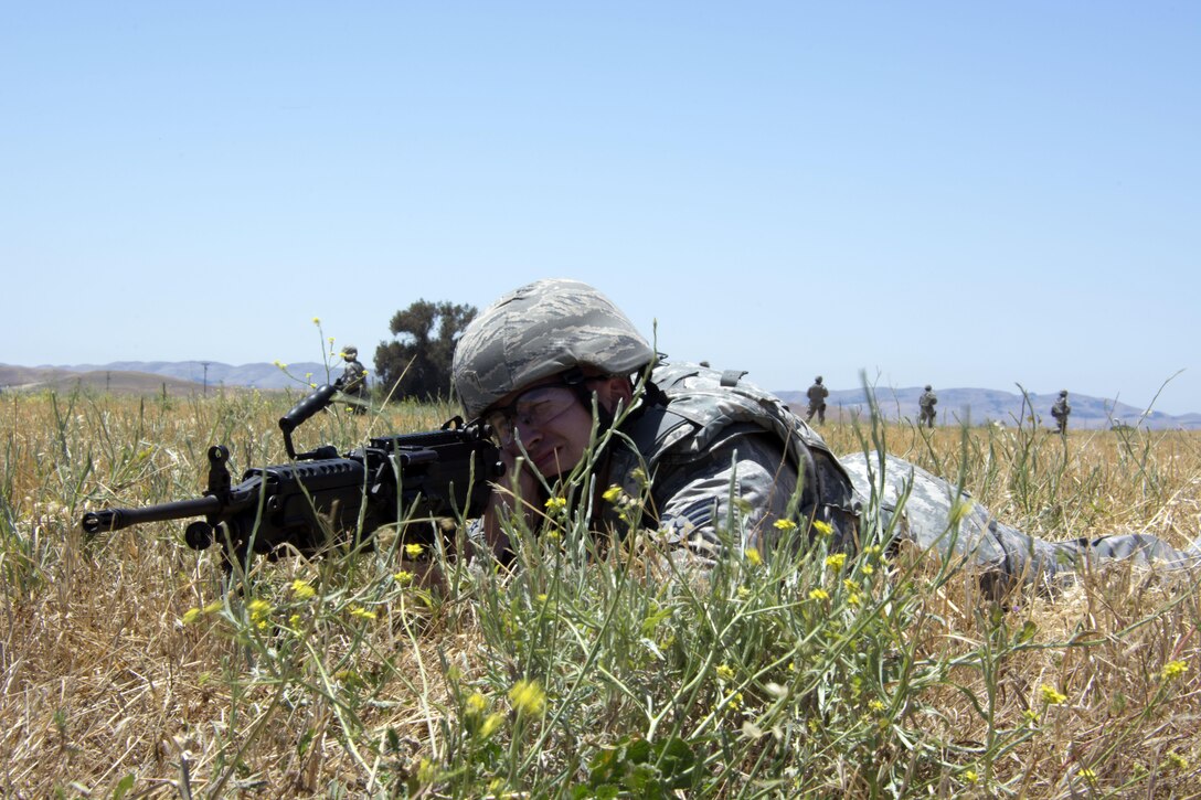 Senior Airman Jake Chanay, 349th Security Forces Squadron, sets up security with his M249 squad automatic weapon June 6, 2015 during a dismounted patrol at Travis Air Force Base, California. More than 40 defenders took part in a various expeditionary combat skills training scenarios during the Air Force Specialty Code weekend. (U.S. Air Force photo/ Staff Sgt. Christopher Carranza)