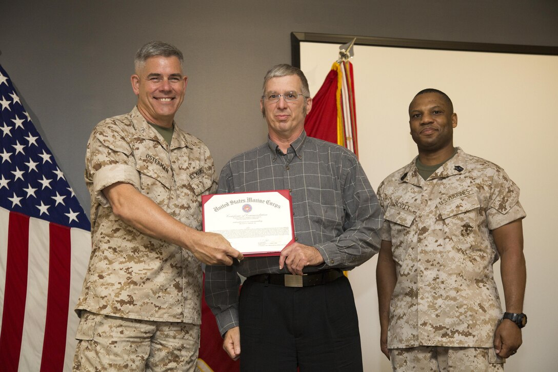 United States Marine Corps Forces Special Operations Command Commander Maj. Gen. Joseph L. Osterman and Sgt. Maj. John W. Scott, the MARSOC sergeant major, present Glenn C. Wright, Jr., a Certificate of Commendation during the MARSOC annual awards ceremony at Stone Bay, aboard Marine Corps Base Camp Lejeune, N.C., June 3, 2015. Wright was selected as the 2014 MARSOC Civilian of the Year. (U.S. Marine Corps photo by Sgt. Scott A. Achtemeier/Released)