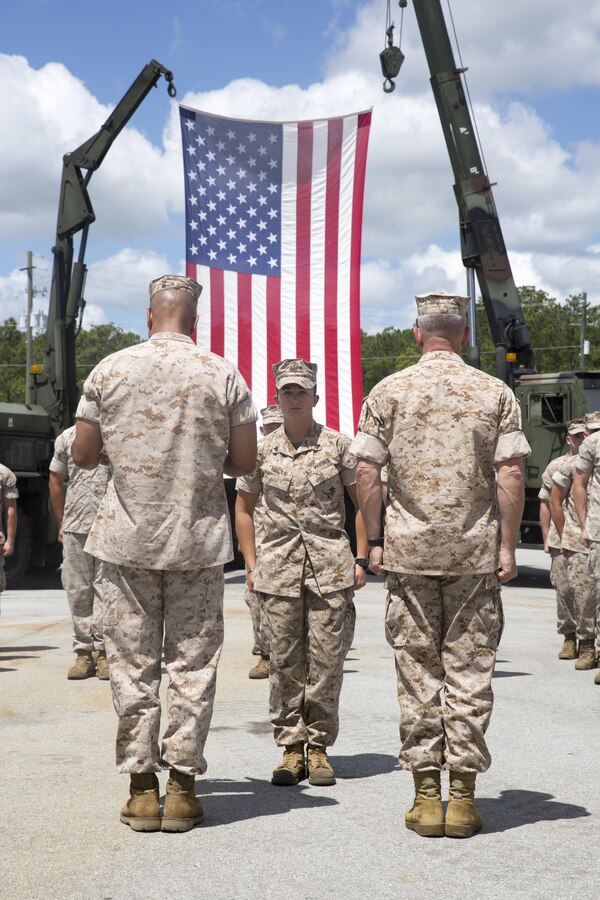 Corporal Rosalie Nolan, a motor transport operator with Marine Special Operations Support Group, U.S. Marine Corps Forces, Special Operations Command, stands at attention as Maj. Gen. Joseph L. Osterman, commander, MARSOC, and 1st Sgt. Darnell E. Patton, MSOSG acting sergeant major, award her during a ceremony at Stone Bay, aboard Marine Corps Base Camp Lejeune, N.C., June 1, 2015. Nolan was selected as the Motor Transport Operator of the Year, one of the categories in the annual U.S. Marine Corps Motor Transport Association Awards. (U.S. Marine Corps photo by Cpl. Steven Fox/Released)