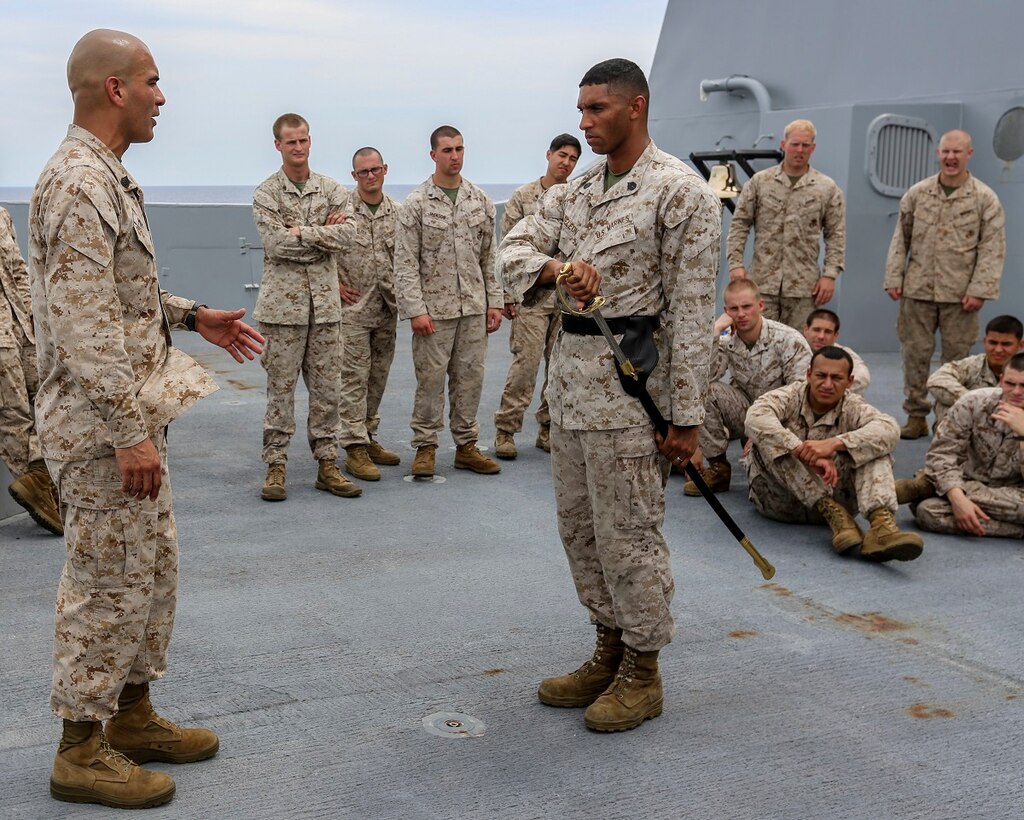 U.S. Marine Staff Sgt. Jose Mireles, left, and Staff Sgt. Josue Deleon demonstrate sword manual for a Corporals Course class aboard the USS Anchorage (LPD 23) in the South China Sea, June 13, 2015. Both Mireles and Deleon are members of Battalion Landing Team 3rd Battalion, 1st Marine Regiment, 15th Marine Expeditionary Unit, and faculty advisors for the Corporals Course aboard the USS Anchorage. Marines participate in corporals courses, even while deployed, to ensure they have the tools to be better leaders. (U.S. Marine Corps photo by Sgt. Steve H. Lopez/Released)