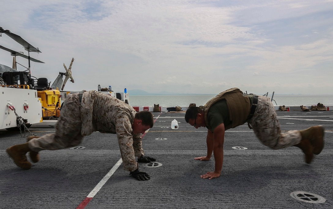 U.S. Marine Sgt. Alejandro Hernandez, right, “does mountain climbers” with a student during a Marine Corps Martial Arts Program, green belt course, aboard the USS Anchorage (LPD 23) in the Strait of Malacca, June 15, 2015. Hernandez is the embark chief with Combat Logistics Battalion 15, 15th Marine Expeditionary Unit. These classes help Marines to maintain physical and mental combat readiness throughout their deployment. (U.S. Marine Corps photo by Sgt. Steve H. Lopez/Released)