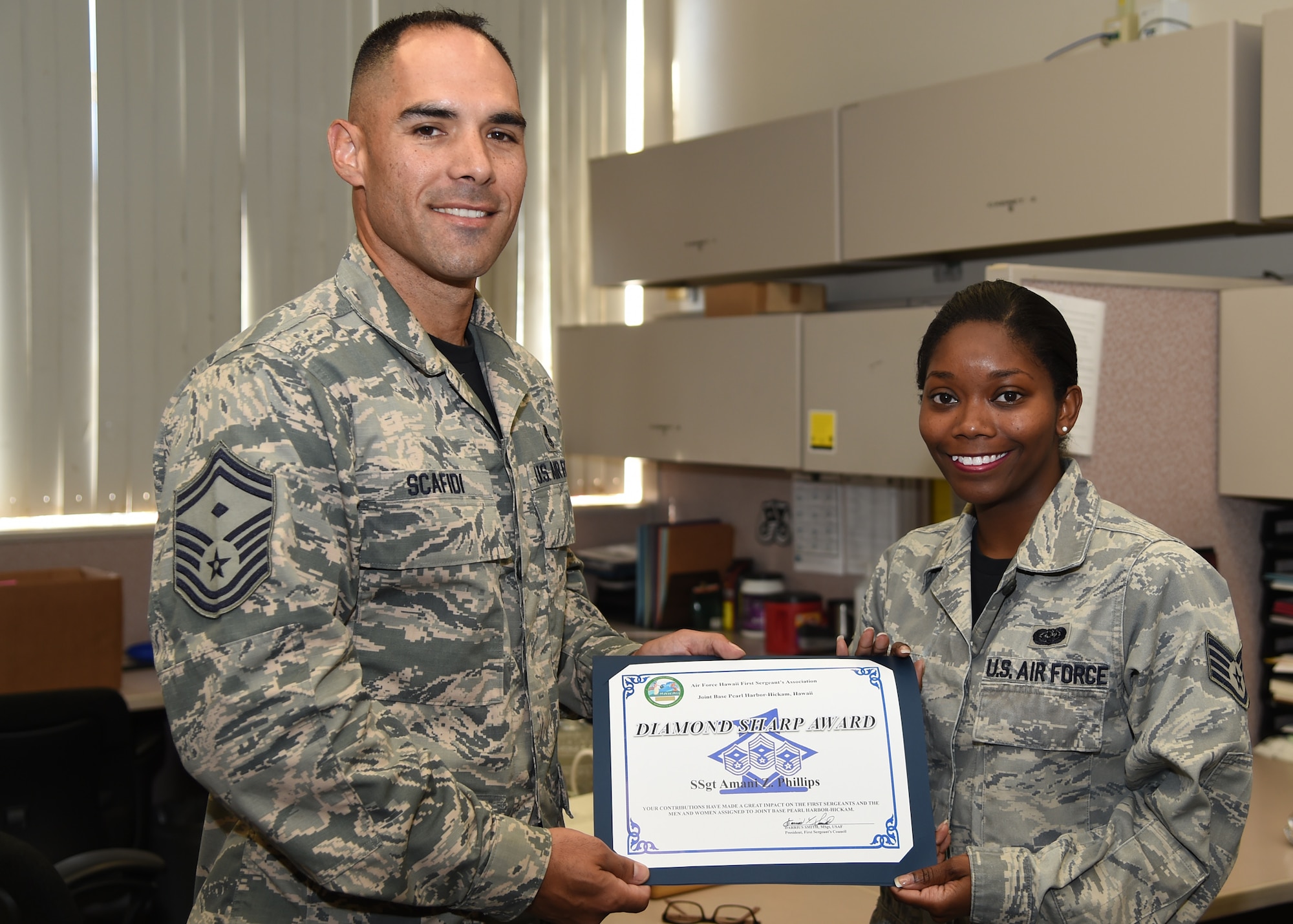 Senor Master Sgt. Kyle Scafidi, 647th Civil Engineer Squadron First Sergeant presents the Diamond Sharp Award to Staff Sgt. Amani Phillips, 647th CES NCOIC Commanders’ support Staff, on Joint Base Pearl Harbor-Hickam, Hawaii, June 12, 2015. The Diamond Sharp Award is a monthly award presented by the Hickam First Sergeants’ Council as an additional way to spotlight exceptional Airmen who are going above and beyond. (U.S. Air Force photo by Tech. Sgt. Aaron Oelrich/Released)