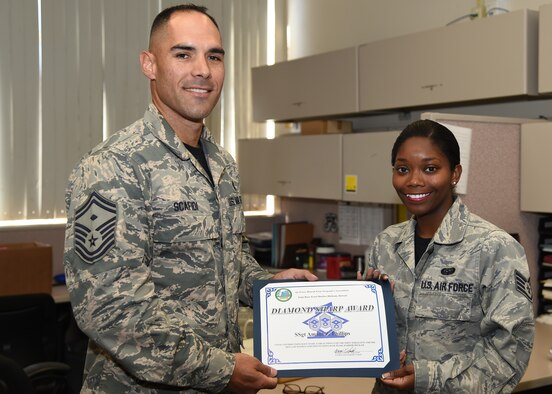 Senor Master Sgt. Kyle Scafidi, 647th Civil Engineer Squadron First Sergeant presents the Diamond Sharp Award to Staff Sgt. Amani Phillips, 647th CES NCOIC Commanders’ support Staff, on Joint Base Pearl Harbor-Hickam, Hawaii, June 12, 2015. The Diamond Sharp Award is a monthly award presented by the Hickam First Sergeants’ Council as an additional way to spotlight exceptional Airmen who are going above and beyond. (U.S. Air Force photo by Tech. Sgt. Aaron Oelrich/Released)