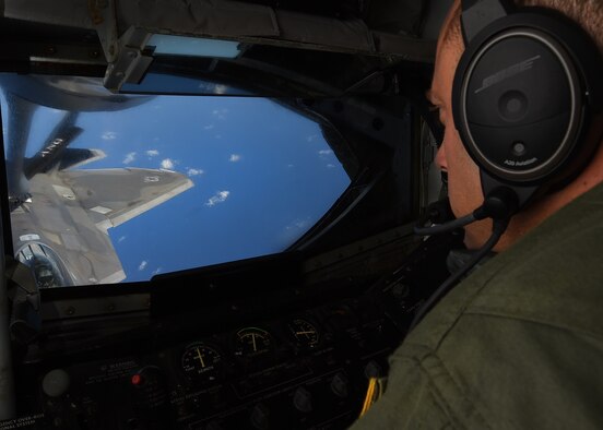 Master Sgt. Joseph Royer, 96th Air Refueling Squadron boom operator, monitors refueling operations of an F-22 Raptor, from 199th Fighter Squadron, during the 96th ARS final operational mission near Joint Base Pearl Harbor-Hickam, Hawaii, June 11, 2015. Royer refueled two raptors and acted as a spotter during defensive maneuvering. (U.S. Air Force Photo by Tech Sgt. Aaron Oelrich/Released)