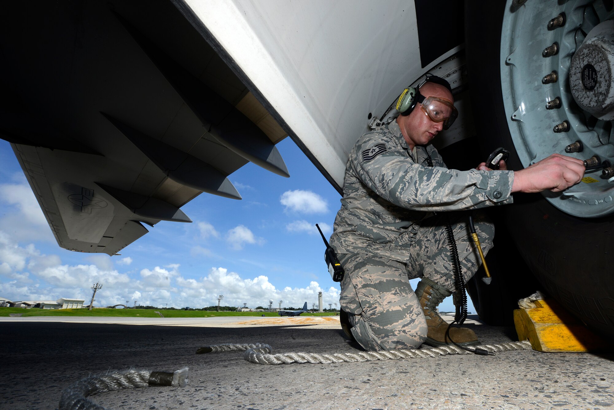 U.S. Air Force Tech. Sgt. David Williamson, 733rd Air Mobility Squadon, checks the air pressure in the tire of a 36th Airlift Squadron C-17 Globemaster III cargo aircraft on the Kadena Air Base, Japan, flightline June 9, 2015. In addition to the hard work he puts into his Air Force career, Williamson also strives to improve his rap career outside the uniform. (U.S. Air Force photo by Staff Sgt. Maeson L. Elleman)
