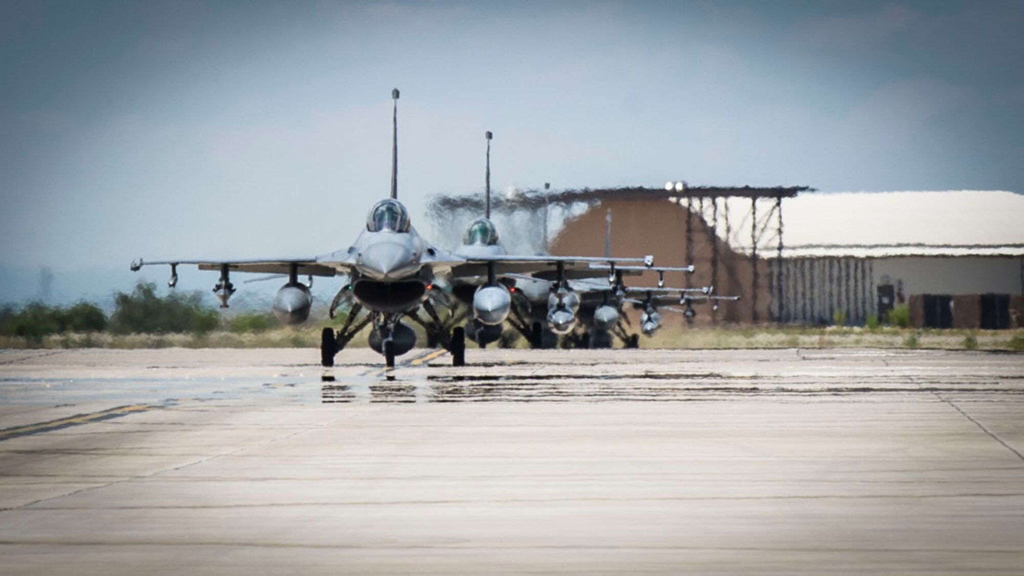 F-16 Fighting Falcons from Luke Air Force Base, Ariz. taxi toward the hangars after arriving at Holloman Air Force Base, N.M., June 16, 2015. The 314th Fighter Squadron and their F-16s have moved their base of operations to Holloman as a tenant unit, along with other squadrons from the 54th Fighter Group. The 314th FS will be soon be activated, replacing the 308th FS as it transitions training operations to Holloman.  (U.S. Air Force photo by Airman 1st Class Emily Kenney / Released)
