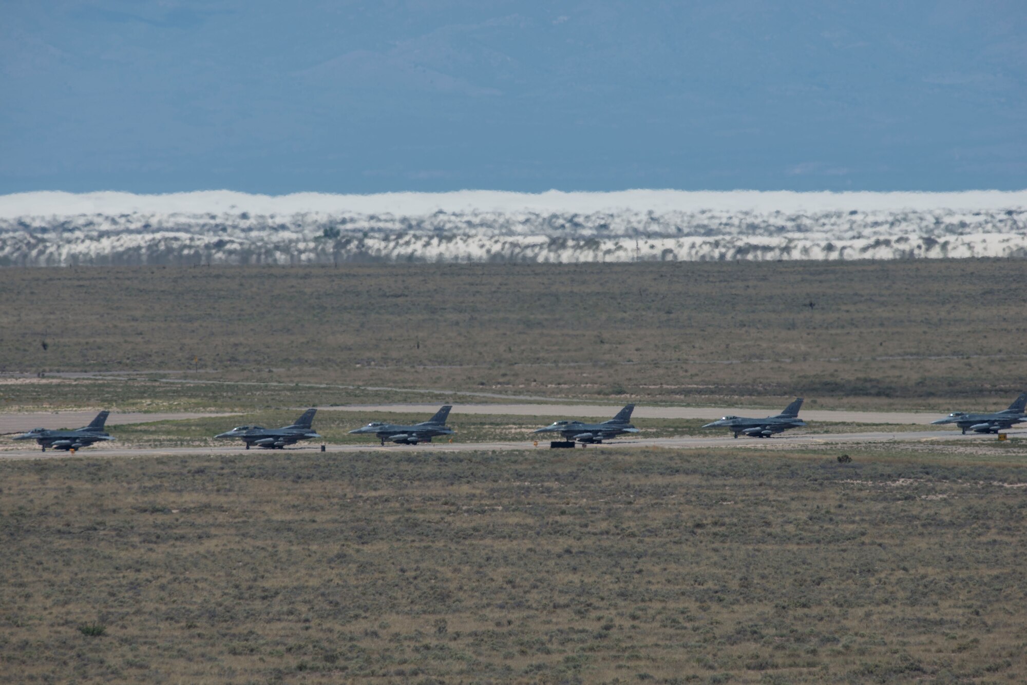 Six of the 12 F-16 Fighting Falcons from Luke Air Force Base, Ariz. arrive at Holloman Air Force Base, N.M, and taxi toward their new hangars, June 16, 2015.  The 308th Fighter Squadron and their F-16s have moved their base of operations to Holloman as a tenant unit, along with other squadrons from the 54th Fighter Group. The 314th FS will be soon be activated so they can continue their training mission at Holloman. (U.S. Air Force photo by Senior Airman Aaron Montoya / Released)
