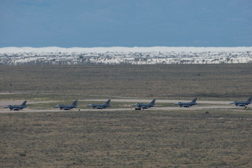 Six of the 12 F-16 Fighting Falcons from Luke Air Force Base, Ariz. arrive at Holloman Air Force Base, N.M, and taxi toward their new hangars, June 16, 2015.  The 308th Fighter Squadron and their F-16s have moved their base of operations to Holloman as a tenant unit, along with other squadrons from the 54th Fighter Group. The 314th FS will be soon be activated so they can continue their training mission at Holloman. (U.S. Air Force photo by Senior Airman Aaron Montoya / Released)