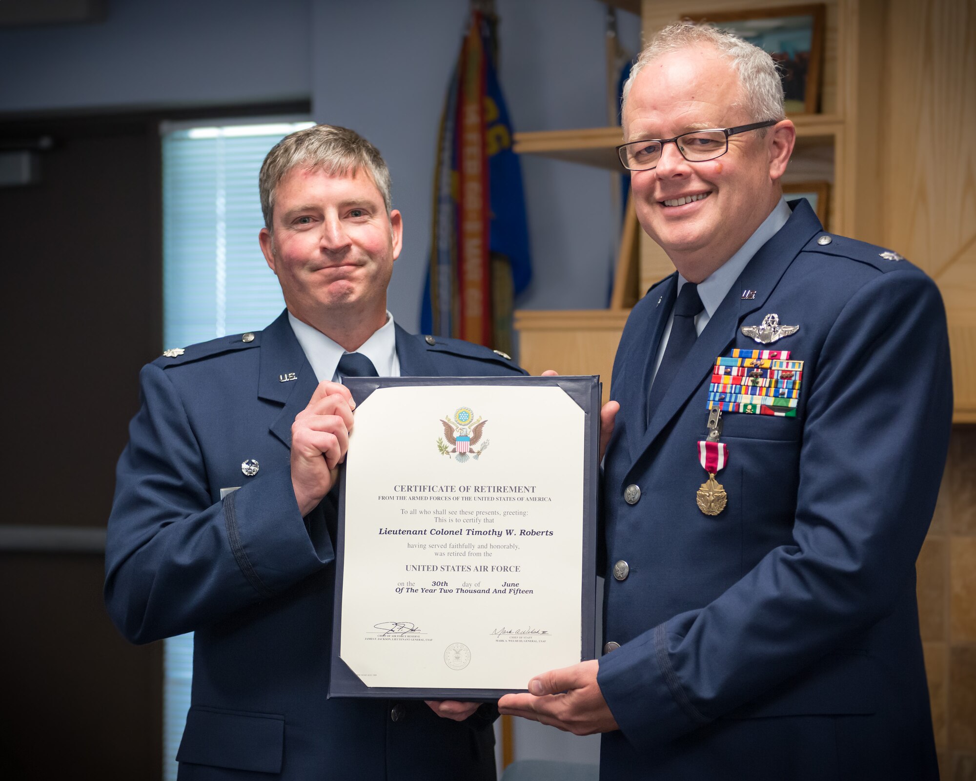 Lt. Col. Derek Poellet, 96th Airlift Squadron commander, presents Lt. Col. Tim Roberts with his certificate of retirement during a ceremony held June 7.  Roberts was also recognized for having over 4,900 mishap free flying hours during his career.  (U.S. Air Force photo by Shannon McKay/Released)