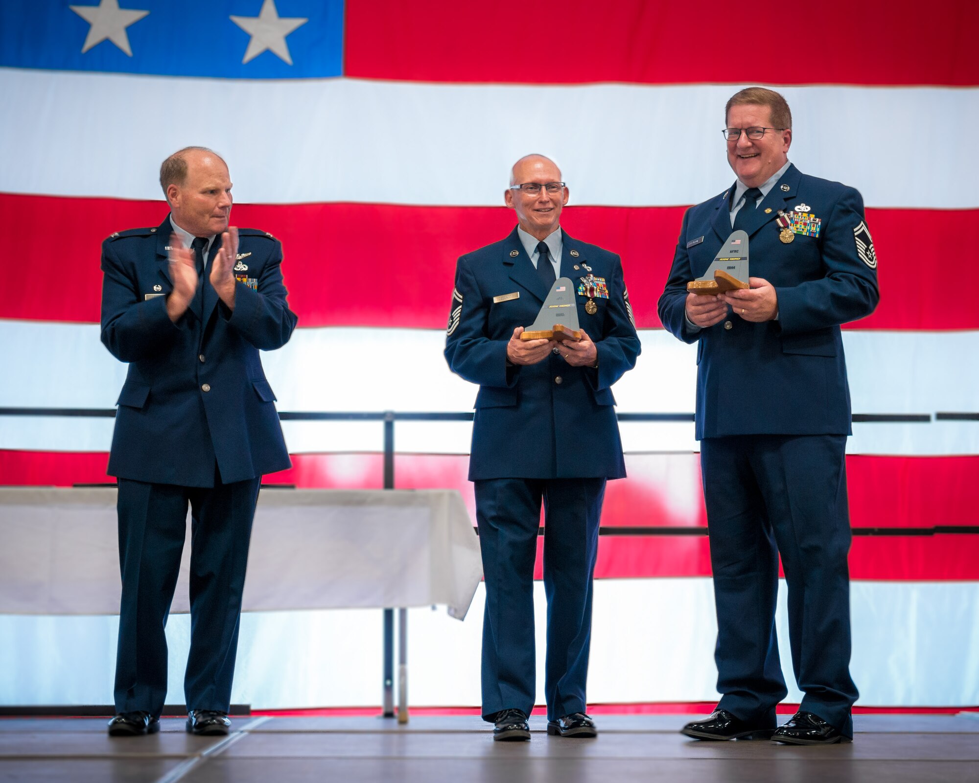 Col. Cam LeBlanc, 934th Maintenance Group commander, presents Senior Master Sgts. Peter DeSanctis and Timothy Payton with a tail flash as part of their joint retirement ceremony during the June unit training assembly weekend at the Minneapolis-St. Paul Air Reserve Station, Minn.  Both served in the Air Force for over 30 years.  (U.S. Air Force photo by Shannon McKay/Released)