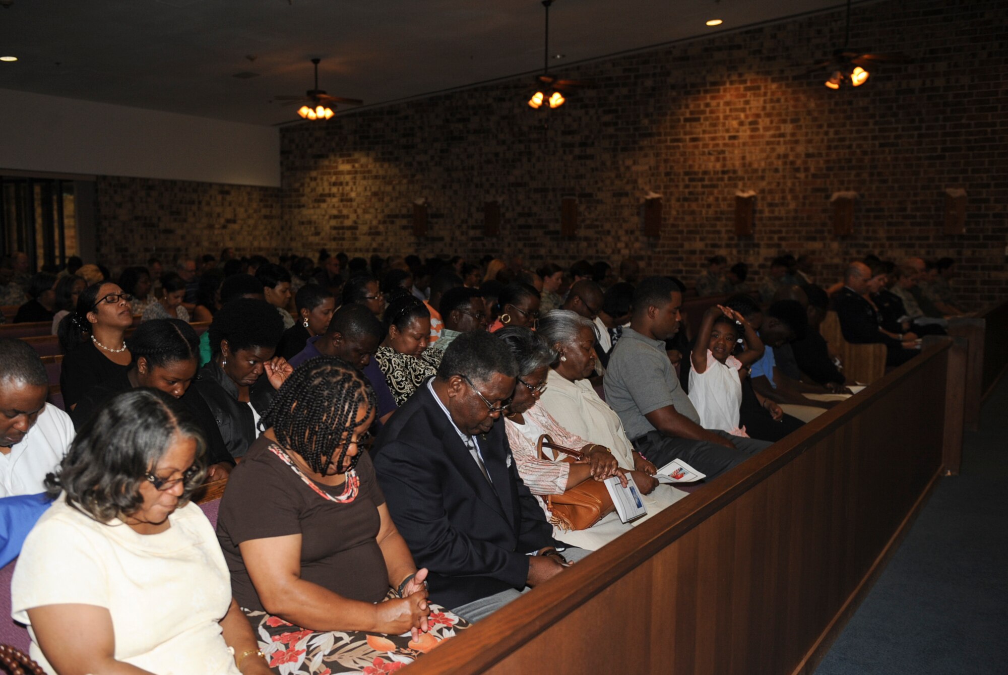 Family and guests have a moment of silence to remember Velma Head during a memorial service June 11, 2015, at Moody Air Force Base, Ga. Members of the 23d Medical Group held a memorial service for Head who passed away on June 3. During the service, co-workers and loved ones shared memories of her and presented a slideshow to celebrate her life. (U.S. Air Force photo by Senior Airman Olivia Bumpers/Released)