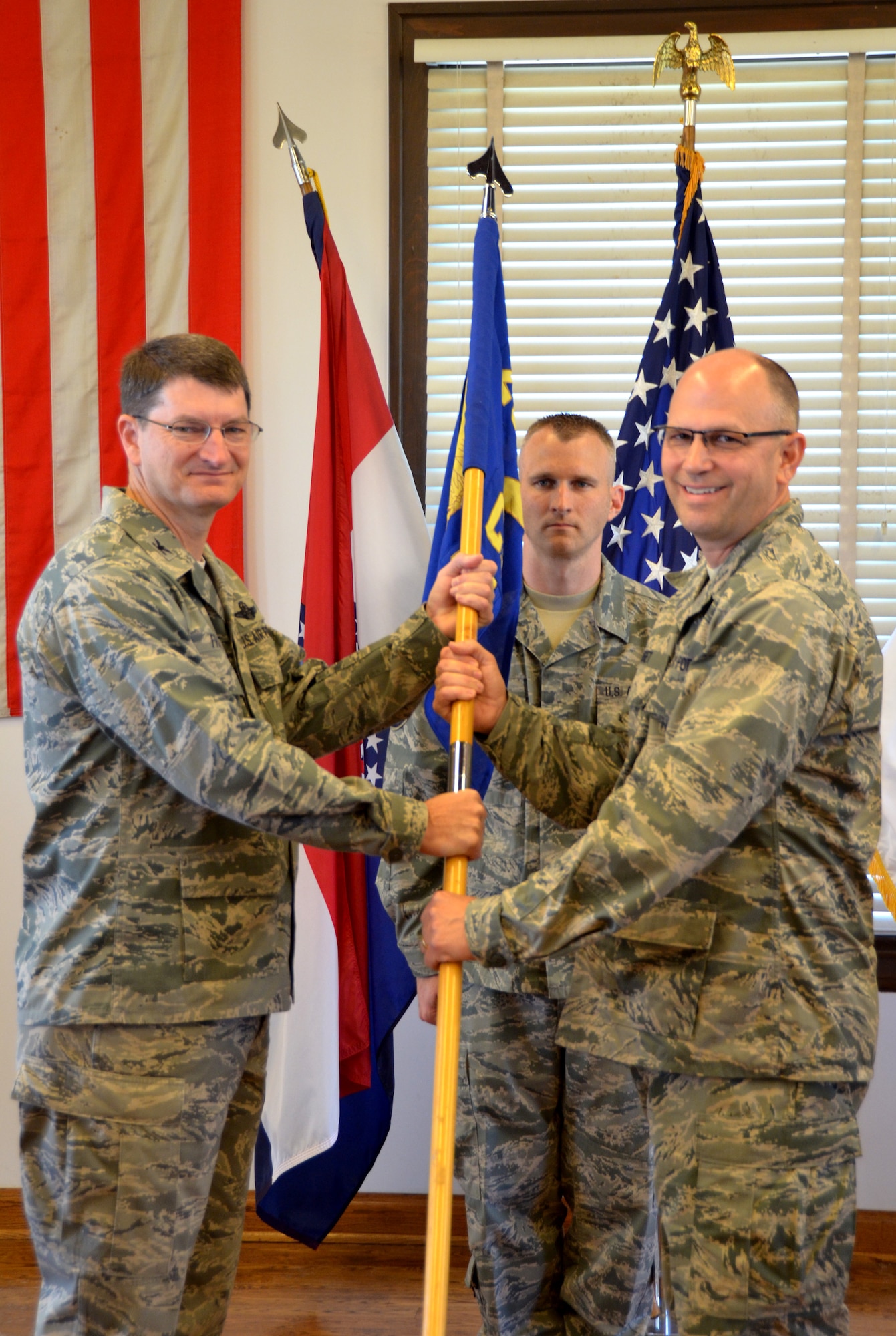 Col. John Miget accepts the guidon from Col. Michael Francis, 131st Bomb Wing commander, as he assumes command of the 231st Civil Engineering Flight from Col. Thomas Hayek, June 6, 2015. (U.S. Air National Guard photo by Staff Sgt. Elise Rich)