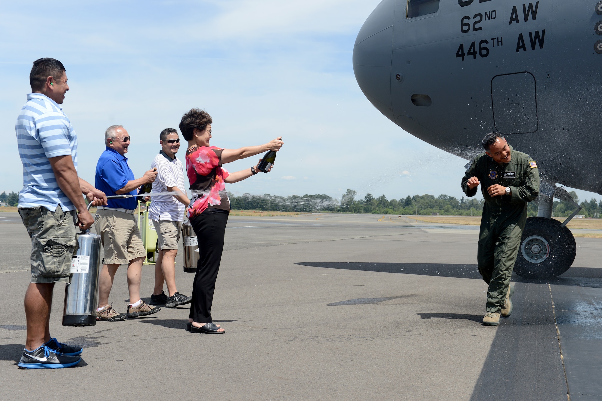 Col. David Kumashiro, 62nd Airlift Wing commander, gets showered with champagne and water by his family after his “fini flight” June 15, 2015, at Joint Base Lewis-McChord, Wash. Kumashiro assumed command of the 62nd Airlift Wing on July 17, 2013. (U.S. Air Force photo/Airman 1st Class Keoni Chavarria)