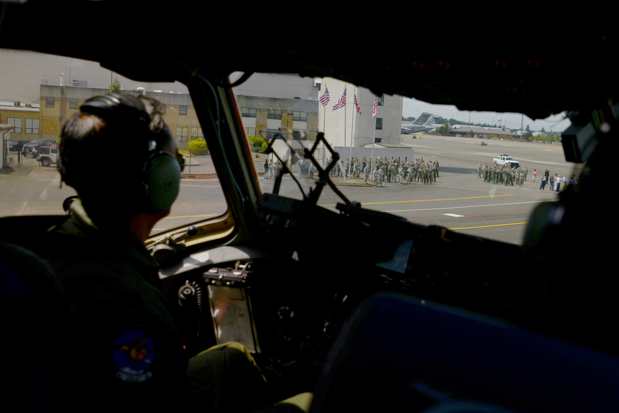 Col. David Kumashiro, 62nd Airlift Wing commander, taxis a C-17 Globemaster III, while his family and friends welcome him June 15, 2015, at Joint Base Lewis-McChord, Wash. For his next assignment, Kumashiro will be going to the Pentagon. (U.S. Air Force photo by Staff Sgt. Tim Chacon)