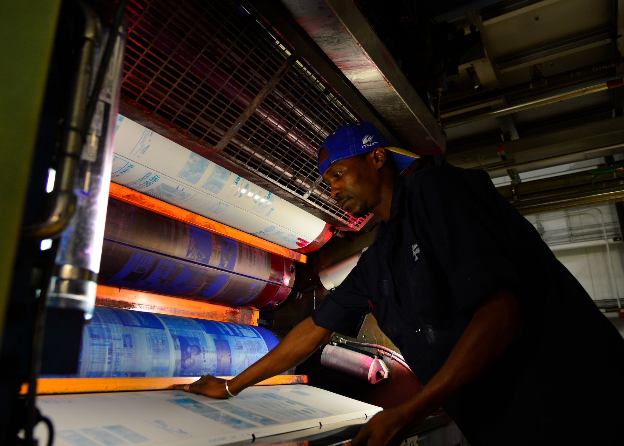 Ty Sample, Delaware Printing Company 2nd pressman, loads an aluminum printing plate onto a print press June 10, 2015, at Delaware Printing Company in Dover, Del. The plates are used by the printing press to transfer the ink onto the paper. (U.S. Air Force photo/Airman 1st Class William Johnson)