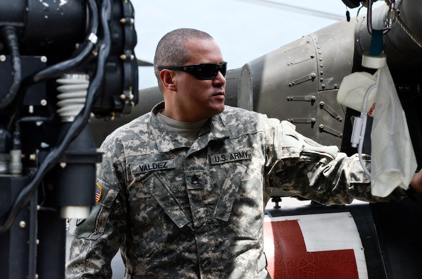 Staff Sgt. Chris Valdez, a 1-228th Aviation Regiment Charlie Company flight medic, waits for supplies to be unloaded from the UH-60 Blackhawk that was used in the rescue of Aaron Rose, a U.S. citizen stranded 18 miles off the coast of Roatan. Valdez hoisted the victim out of the water after he had been floating for more than 15 hours at sea. (U.S. Air Force photo by Staff Sgt. Jessica Condit) 