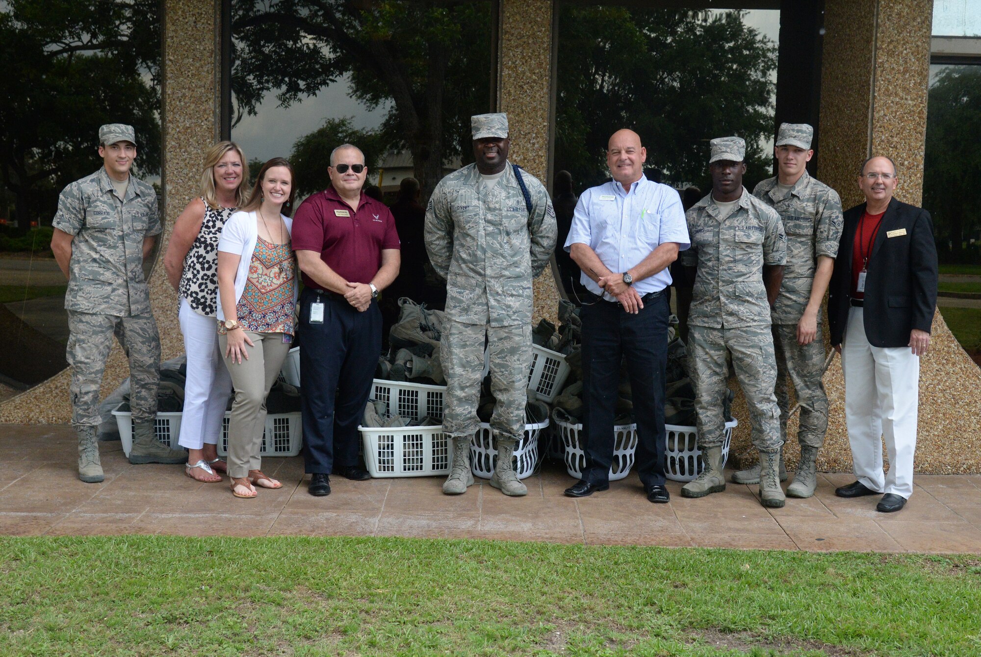 Staff Sgt. Robinson Divert, 334th Training Squadron military training leader, (center) poses for a group photo with representatives from Humana, Keesler Federal Credit Union and Airmen from the 81st Training Group in front of his boot donation, June 2, 2015, Keesler Air Force Base, Miss. Divert, with the help of Keesler Federal Credit Union and Humana, helped organize the donation of approximately 200 pairs of boots for Gulf Coast homeless veterans.  (U.S. Air Force photo by Senior Airman Holly Mansfield)