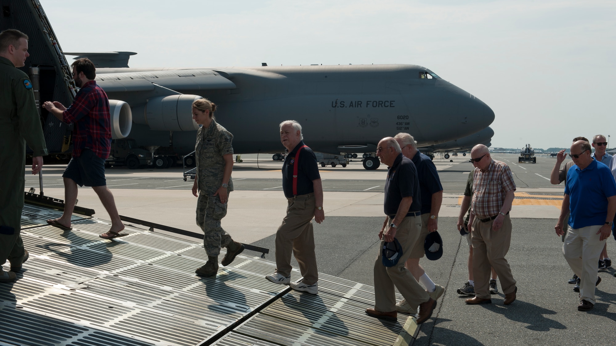 Air Mobility Command Museum volunteers are lead up the forward ramp of a C-5M Super Galaxy June 13, 2015, at Dover Air Force Base, Del. Sixteen museum volunteers received the opportunity to tour the aircraft. (U.S. Air Force photo/Airman 1st Class Zachary Cacicia)