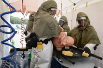 A simulated victim is washed in a decontamination tent by members of the squadron's decontamination team outside the 66th Medical Squadron during a training session June 11. The MDS team participated in the training to better respond to a chemical, biological and nuclear decontamination event. (U.S. Air Force photo by Jerry Saslav) 