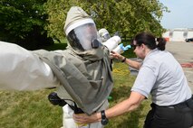 Dr. Theresa Casey, Decontamination, Education and Consulting on Nuclear Biological and Chemical Decontamination master instructor, checks to ensure that protective gear worn by Staff Sgt. Sonia Severino, 66th Medical Squadron Pharmacy technician and member of the squadron decontamination team, is properly sealed during a training exercise June 12. The training ensures the in-place patient decontamination team knows how to rapidly and effectively deploy the equipment for timely response. (U.S. Air Force photo by Jerry Saslav) 