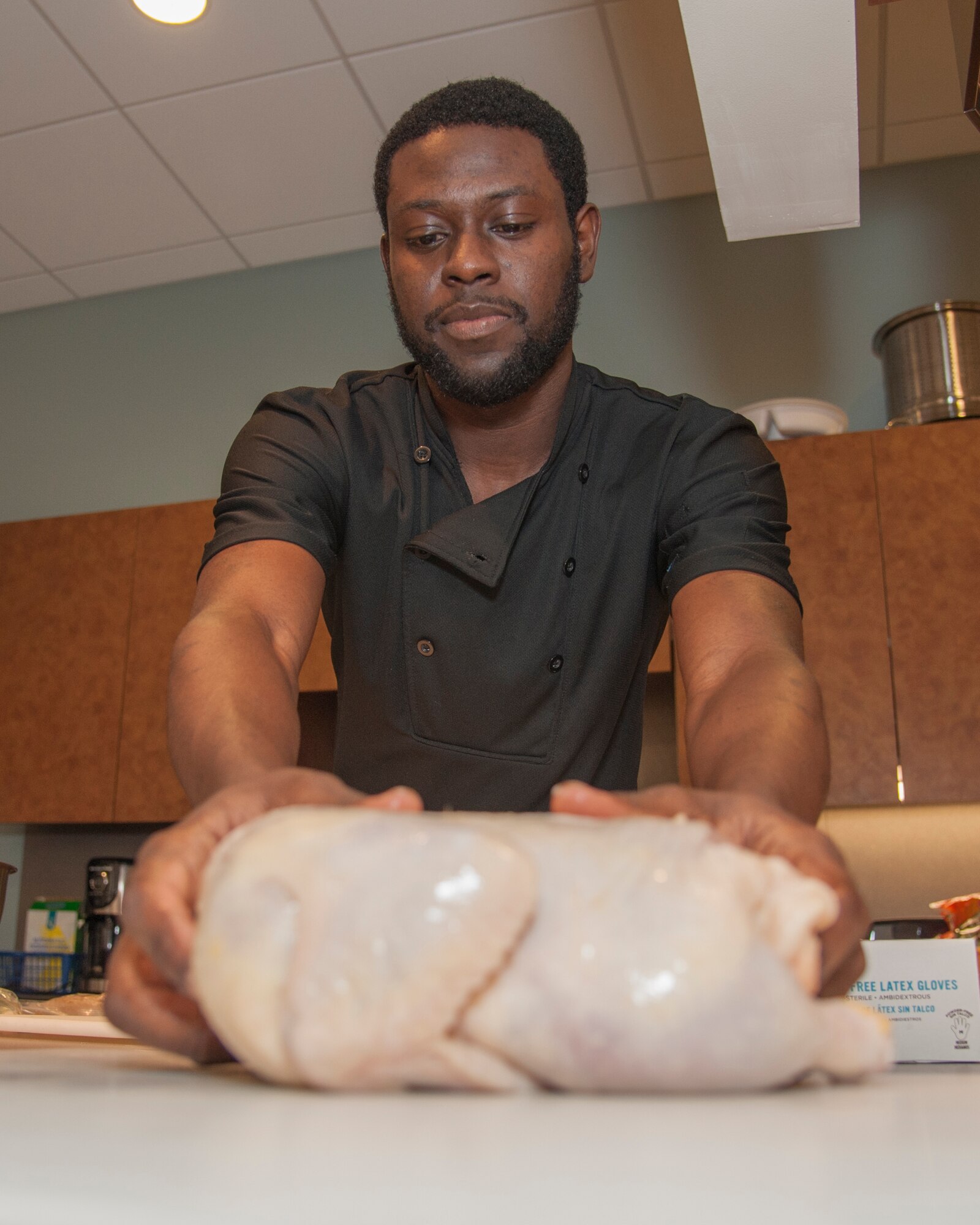 Sameer “Frenchie” Hunter prepares chicken before the start of Dorm to Gourm June 9, 2015, at the Health Promotion Flight kitchen in the Fitness Center on Dover Air Force Base, Del. Hunter is a chef at Governor’s Café in downtown Dover and worked with Airmen to create three chicken recipes. (U.S. Air Force photo/Senior Airman Jared Duhon) 