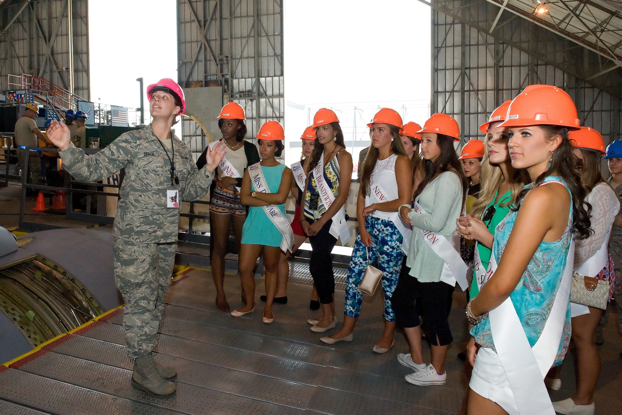 Tech. Sgt. Jennifer Dellis, 512th Maintenance Squadron aircraft crew chief, briefs Miss Delaware 2015 contestants on the C-5 Isochronal inspection process June 11, 2015, on Dover Air Force Base, Del. The contestants walked on top of and through a C-5A Galaxy currently going through a major Isochronal inspection. (U.S. Air Force photo/Roland Balik)
