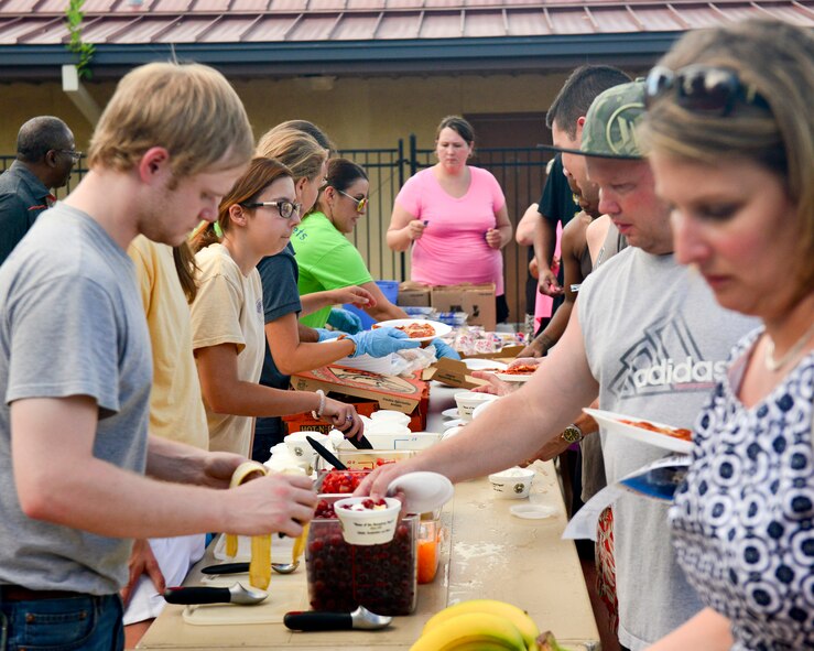 Members of Team Barksdale line up for food during the annual Pool Bash on Barksdale Air Force Base, La., June 12, 2015. In addition to food, guests were provided with music and free pool toys during the event. (U.S. Air Force photo/Airman 1st Class Mozer O. Da Cunha)