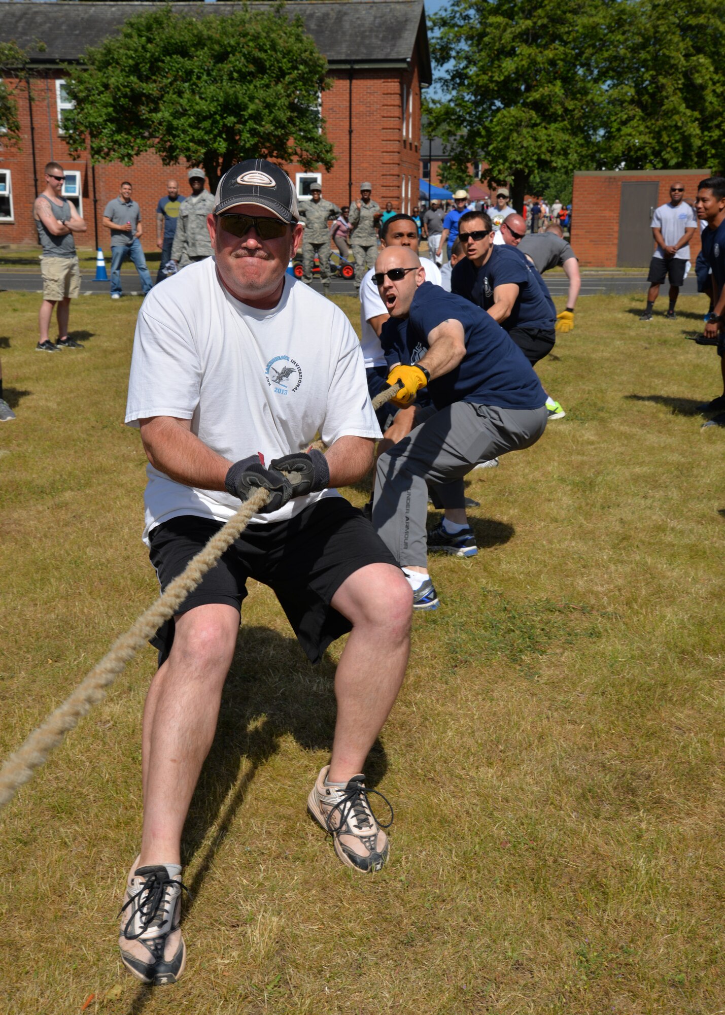 Members of the 100th Civil Engineer Squadron “A” team yell and pull during a tug-of-war competition at the Marauder Melee June 11, 2015, on RAF Mildenhall, England. The event began with sports competitions which included volleyball, soccer and tennis, and opened up to families in the afternoon. The 100th Air Refueling Wing Staff Agency team won this year’s trophy. (U.S. Air Force photo by Karen Abeyasekere/Released)