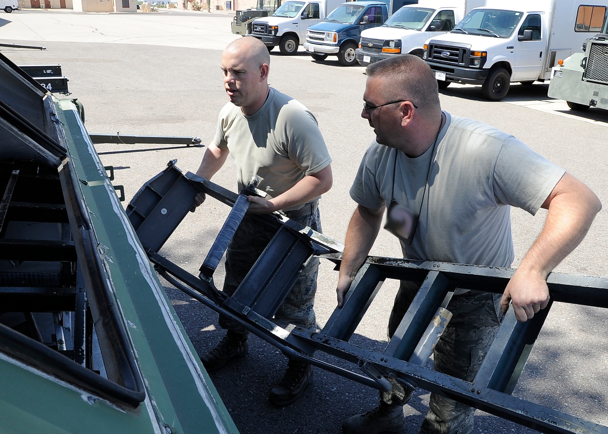 Staff Sgt. David Patton, 308th Aircraft Maintenance Unit support floor chief, and Tech. Sgt. Jeremy Shonkwiler, 308th AMU NCO-in charge, loads ladders into a crate June 2 at Luke Air Force Base. The 308th Fighter Squadron and AMU are formally standing down and are packing for the move to Holloman Air Force Base, New Mexico. There they will stand up as the 314th FS and AMU, the second F-16 unit at Holloman. 
