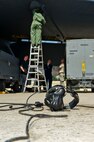 A headset lies on the ground in front of Airmen from the 5th Aircraft Maintenance Squadron working beneath the wing of a B-52H Stratofortress at Minot Air Force Base, N.D., June 11, 2015.  Current engineering analyses show the B-52H's life span to extend beyond the year 2040 because of regular maintenance performed by the 5th AMXS. (U.S. Air Force photo/Airman 1st Class Justin T. Armstrong)