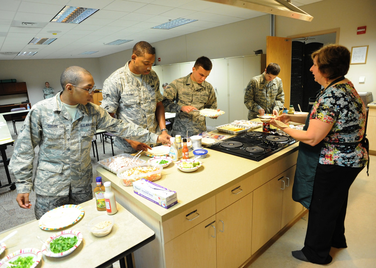 Veteran Chef Dianna Ackerley teaches Joint Base San Antonio-Randolph Airmen healthy cooking habits on a budget while making sandwich wraps and pasta salads during the kitchen addiction cooking class at the Joint Base San Antonio-Randolph Human Performance Resource Center.  The cooking classes, originally designed to provide Airmen cooking skills during the renovation of the JBSA-Randolph Rendezvous  Dining Facility, is now open to all Airmen E-4 and below.  (U.S. Air Force photo by Melissa Peterson)