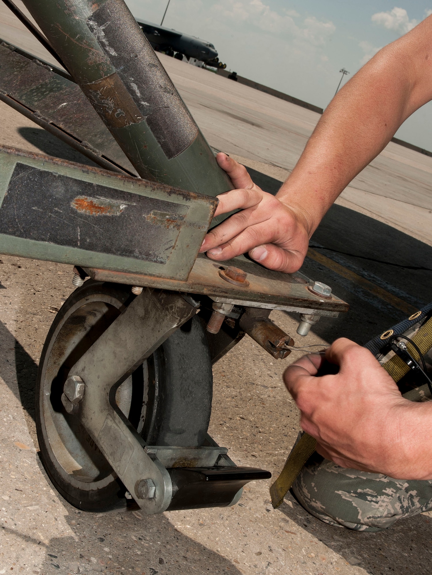 An Airman from the 5th Aircraft Maintenance Squadron locks a B-204 maintenance stand in place near a B-52H Stratofortress at Minot Air Force Base, N.D., June 11, 2015. Safety is a top priority for Airmen working on the flightline and they follow strict guidelines to ensure proper steps are taken to protect Airmen and equipment from harm. (U.S. Air Force photo/Senior Airman Stephanie Morris)