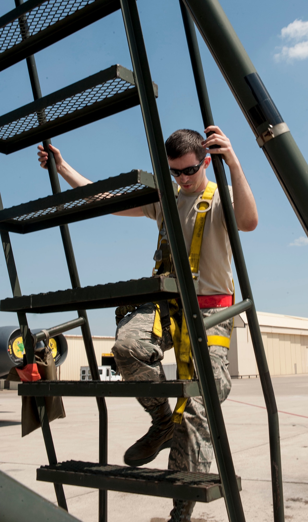 Airman Michael Henderson, 5th Aircraft Maintenance Squadron crew chief, descends a B-204 maintenance stand next to a B-52H Stratofortress at Minot Air Force Base, N.D., June 11, 2015. Henderson used the stand to safely reach the in-flight refueling door located at the top of the aircraft. (U.S. Air Force photo/Senior Airman Stephanie Morris)
