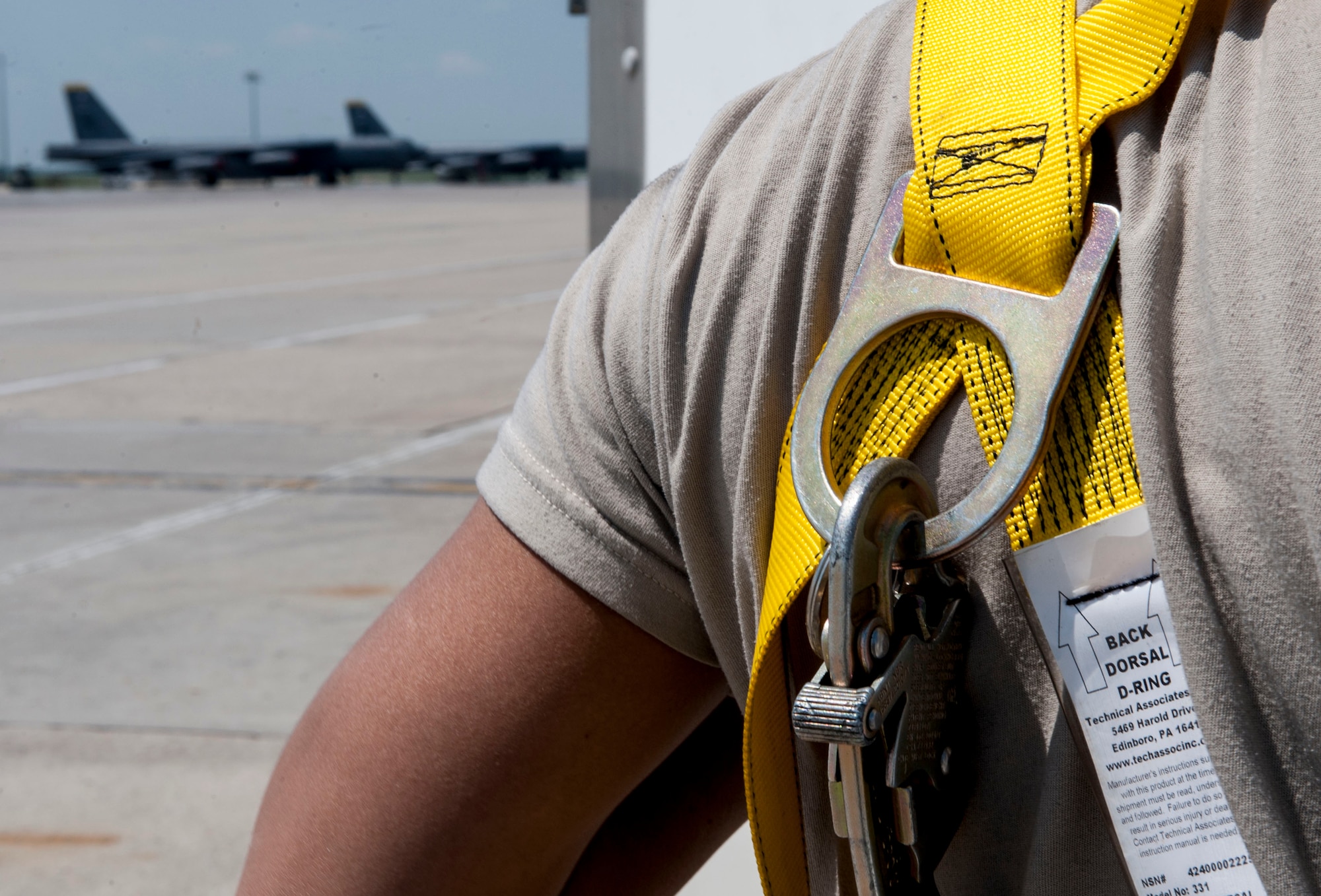 A safety line is clipped to the back dorsal ring of a harness worn by a 5th Aircraft Maintenance Squadron crew chief at Minot Air Force Base, N.D., June 11, 2015. The harness was used while Airman performed maintenance checks on the wings and top section of a B-52H Stratofortress. (U.S. Air Force photo/Senior Airman Stephanie Morris)