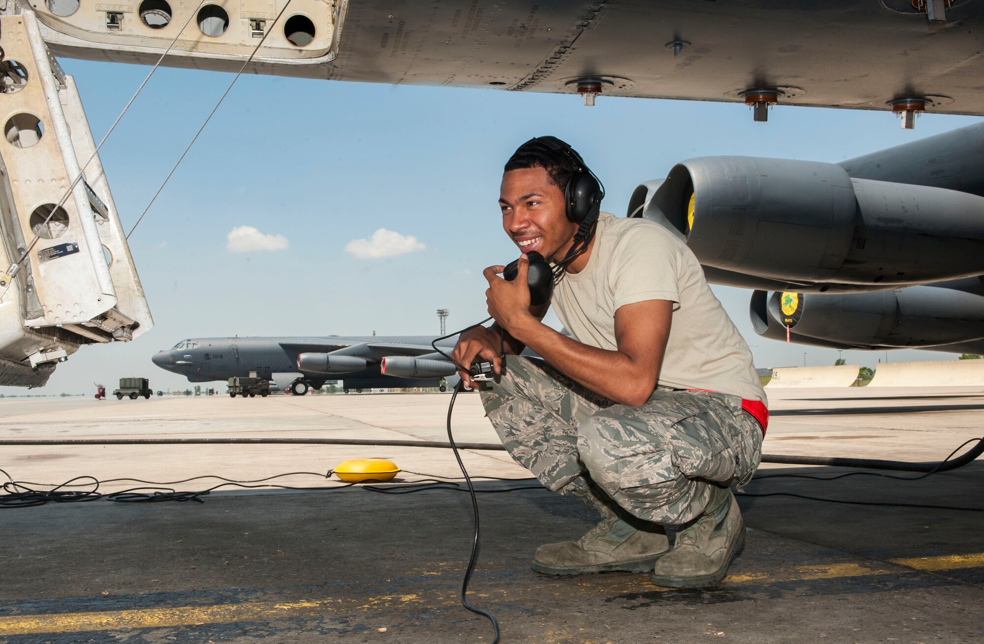 Airman 1st Class Lloyd Haynes, 5th Aircraft Maintenance Squadron crew chief, speaks to Airmen in the cockpit of a B-52H Stratofortress through a headset at Minot Air Force Base, N.D., June 11, 2015. Haynes was part of a group of Airmen receiving on-the-job training for B-52H maintenance procedures. (U.S. Air Force photo/Senior Airman Stephanie Morris)