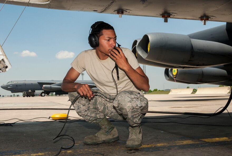 Airman 1st Class Lloyd Haynes, 5th Aircraft Maintenance Squadron crew chief, speaks to Airmen in the cockpit of a B-52H Stratofortress through a headset at Minot Air Force Base, N.D., June 11, 2015. Haynes was part of a group of Airmen receiving on-the-job training for B-52H maintenance procedures. (U.S. Air Force photo/Senior Airman Stephanie Morris)
