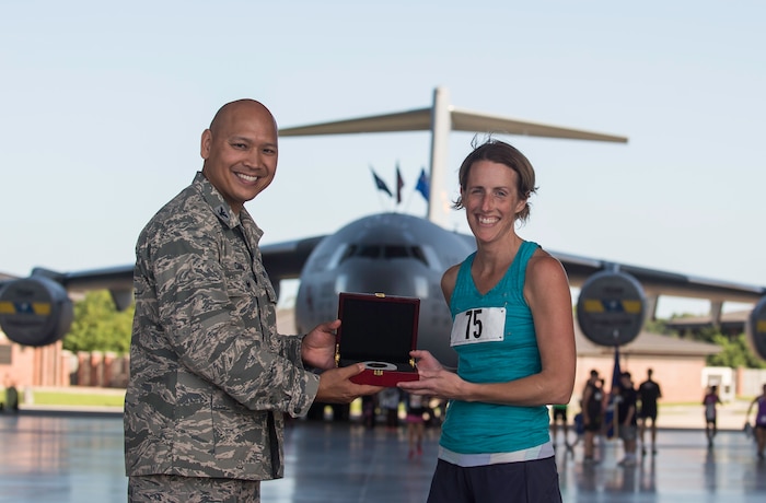 Katherine McEvoy poses with Col. Jimmy Canlas while holding a piece of the runway after the “Run the Runway 5k” event June 13, 2015, at Joint Base Charleston S.C.  The annual event, now open to the public, was conducted on a 3.1 mile course certified by USA Track and Field.  McEvoy was the fastest female with a time of 21:17. Canlas is the 437th Airlift Wing vice commander. (U.S. Air Force photo/Senior Airman Jared Trimarchi)