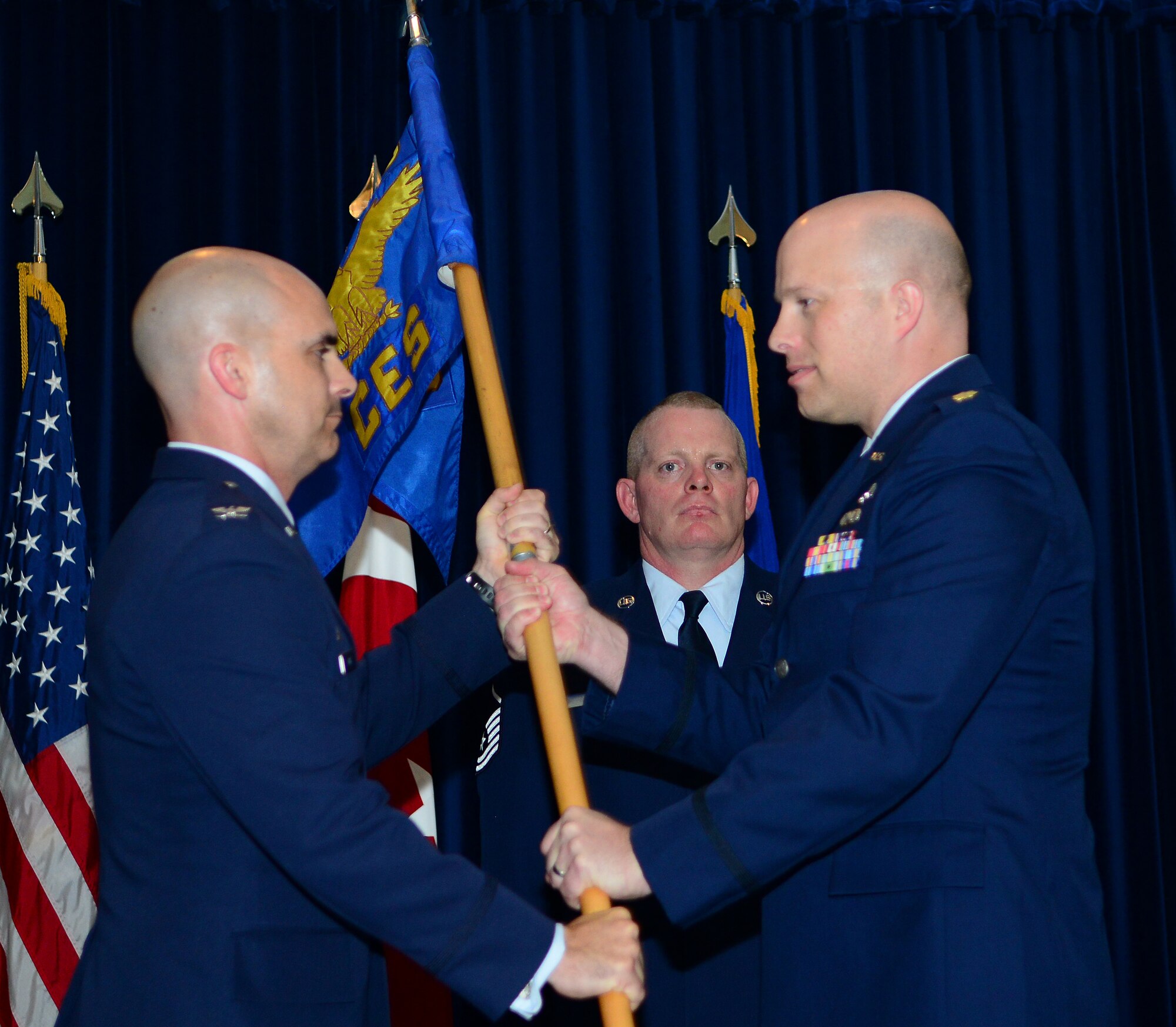 Col. Russell Voce, 39th Mission Support Group commander, passes the guidon to Maj. Karl Recksiek, 39th Civil Engineer Squadron commander, during the 39th CES change of command ceremony June 16, 2015, at Incirlik Air Base, Turkey. A change of command ceremony is a tradition that represents a formal transfer of authority and responsibility from the outgoing commander to the incoming commander. (U.S. Air Force photo by Staff Sgt. Caleb Pierce/Released) 