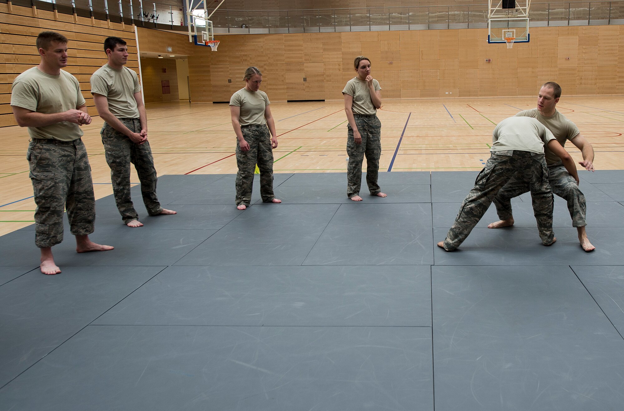 U.S. Air Force Senior Airman Erik Alter, 52nd Security Forces Squadron lead combatives instructor, demonstrates a technique to Airmen from the 52nd SFS during combatives training May 28, 2015 at the fitness center on Spangdahlem Air Base, Germany. All law enforcement officers assigned to the 52nd SFS are required to complete basic hand-to-hand combat training, meant to prepare them for any unexpected encounters on the job. (U.S. Air Force photo by Staff Sgt. Chad Warren/Released)