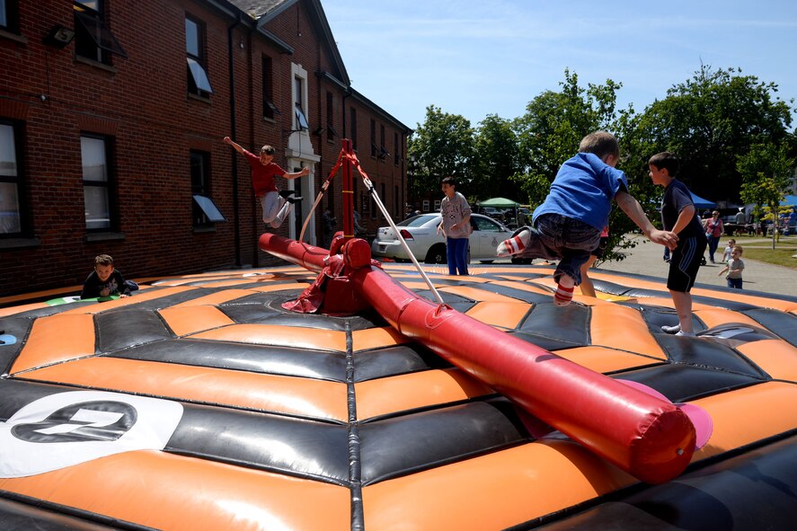 Team Mildenhall children play on a bouncy attraction at the Marauder Melee June 11, 2015, on RAF Mildenhall, England. Besides an all-day sports competition amongst groups and squadrons across base, the event hosted food and games for Team Mildenhall and their families. (U.S. Air Force photo by Senior Airman Kate Thornton/Released)