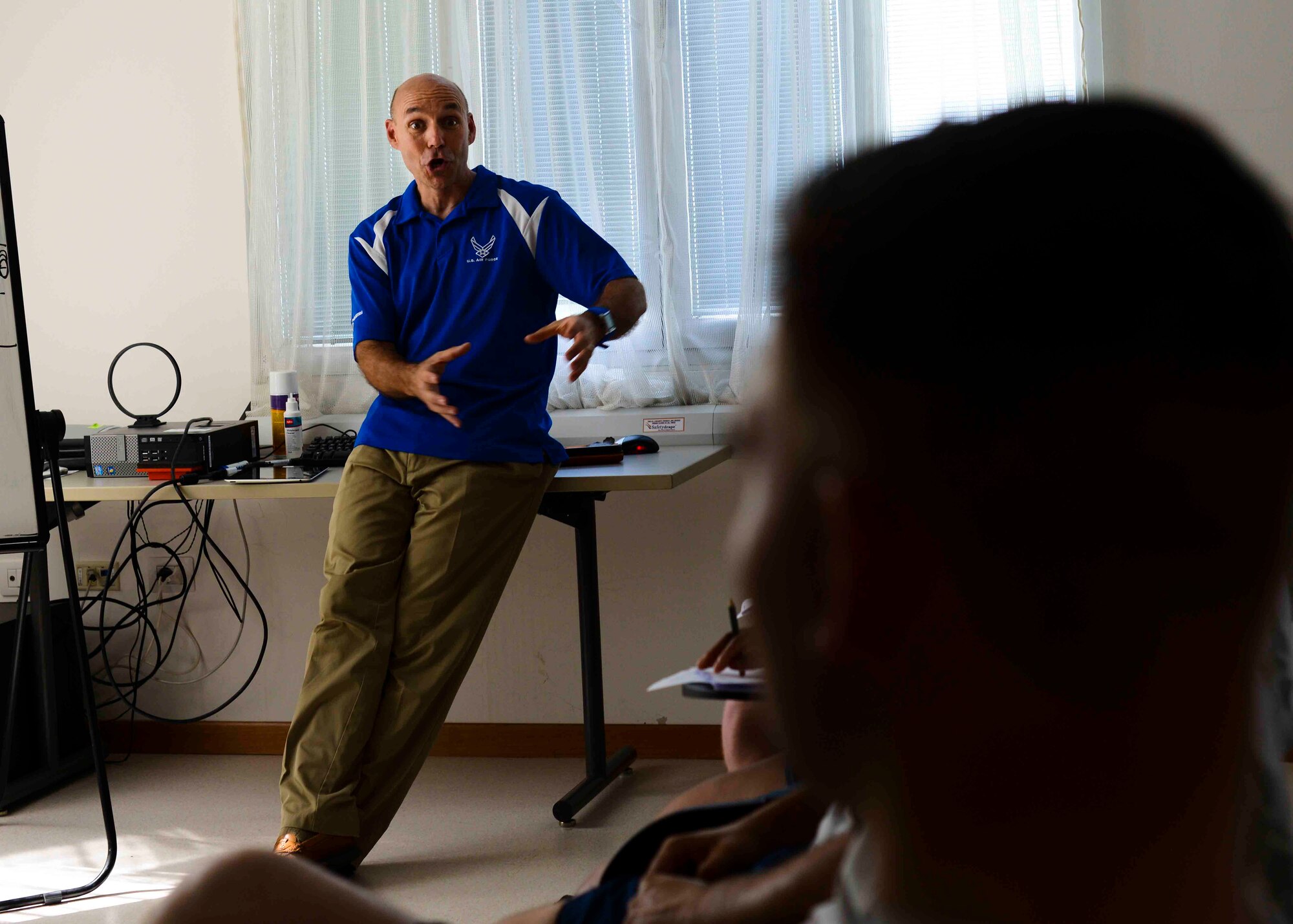 Kevin Egger, Health Promotion coordinator, speaks with Airmen about proper running form during a running clinic June 8, 2015, at Aviano Air Base, Italy. These classes offer Airmen a one-on-one counseling session about individual running form and technique. (U.S. Air Force photo by Senior Airman Austin Harvill/Released)