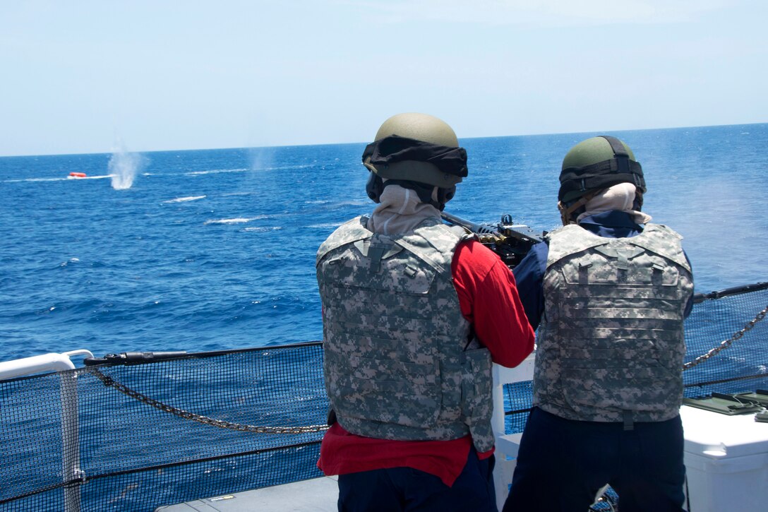 U.S. Coast Guard Petty Officer 3rd Class Marisa Moe, Right, Fires At A ...