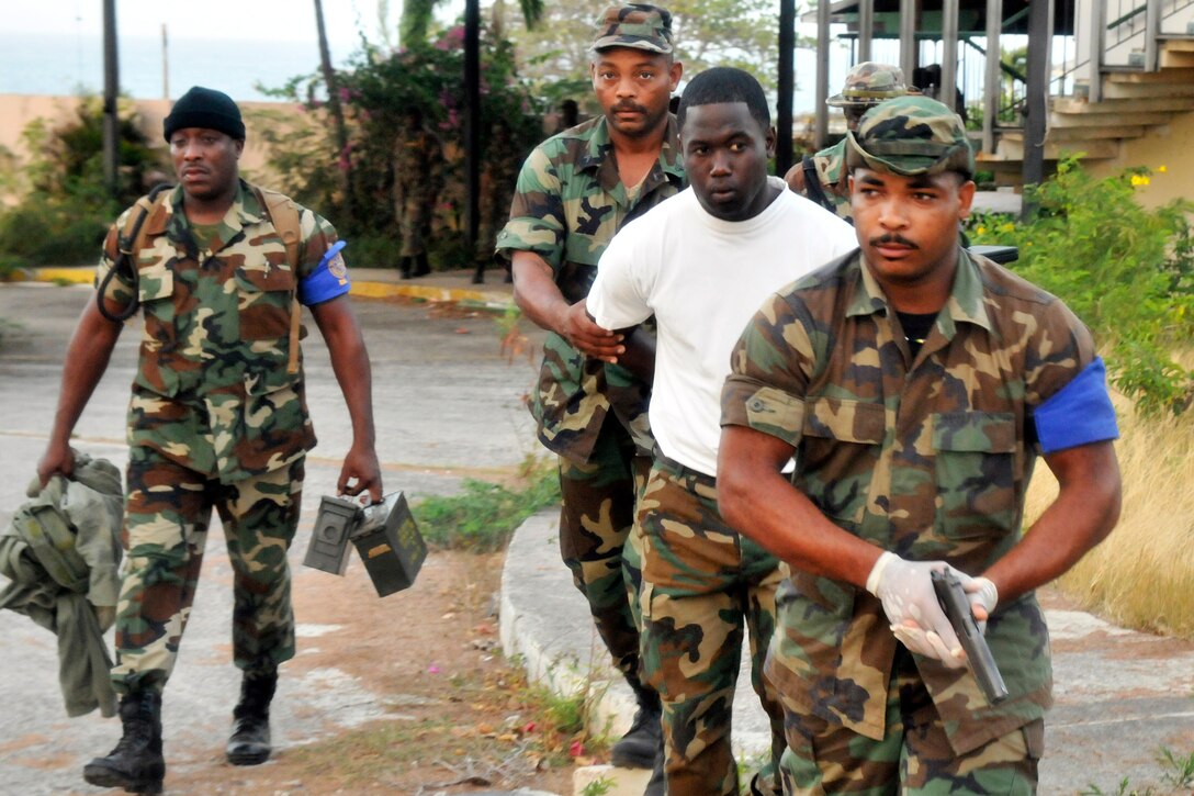 Members of the Regional Security System, which includes personnel from multiple Caribbean nations, escort a role player acting as a suspect for a Tradewinds 2015 training event in Basseterre, St. Kitts, June 7, 2015.