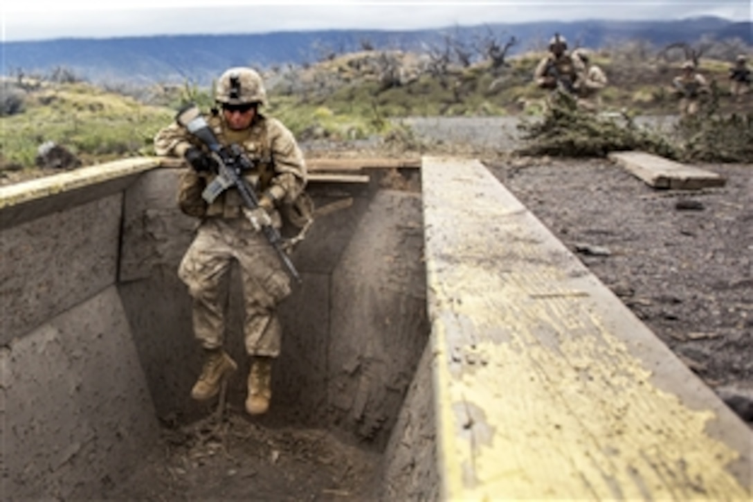 A Marine leaps down into trench during an assault exercise as part of Operation Lava Viper at Pohakuloa Training Area, Hawaii, June 9, 2015. The Marines are assigned to Charlie Company, 1st Battalion, 3rd Marine Regiment. 
