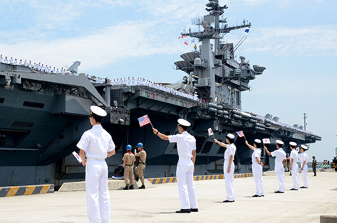 BUSAN, Republic of Korea (Jul. 11, 2014) Republic of Korea sailors wave South Korean and American flags as the aircraft carrier USS George Washington (CVN73) arrives in Busan, Republic of Korea for a scheduled port visit. George Washington is forward deployed to Yokosuka, Japan in the U.S. 7th Fleet area of responsibility supporting regional security and stability in the Indo-Asia Pacific Region. (U.S. Navy photo by Mass Communication Specialist 1st Class Frank L. Andrews/Released) 