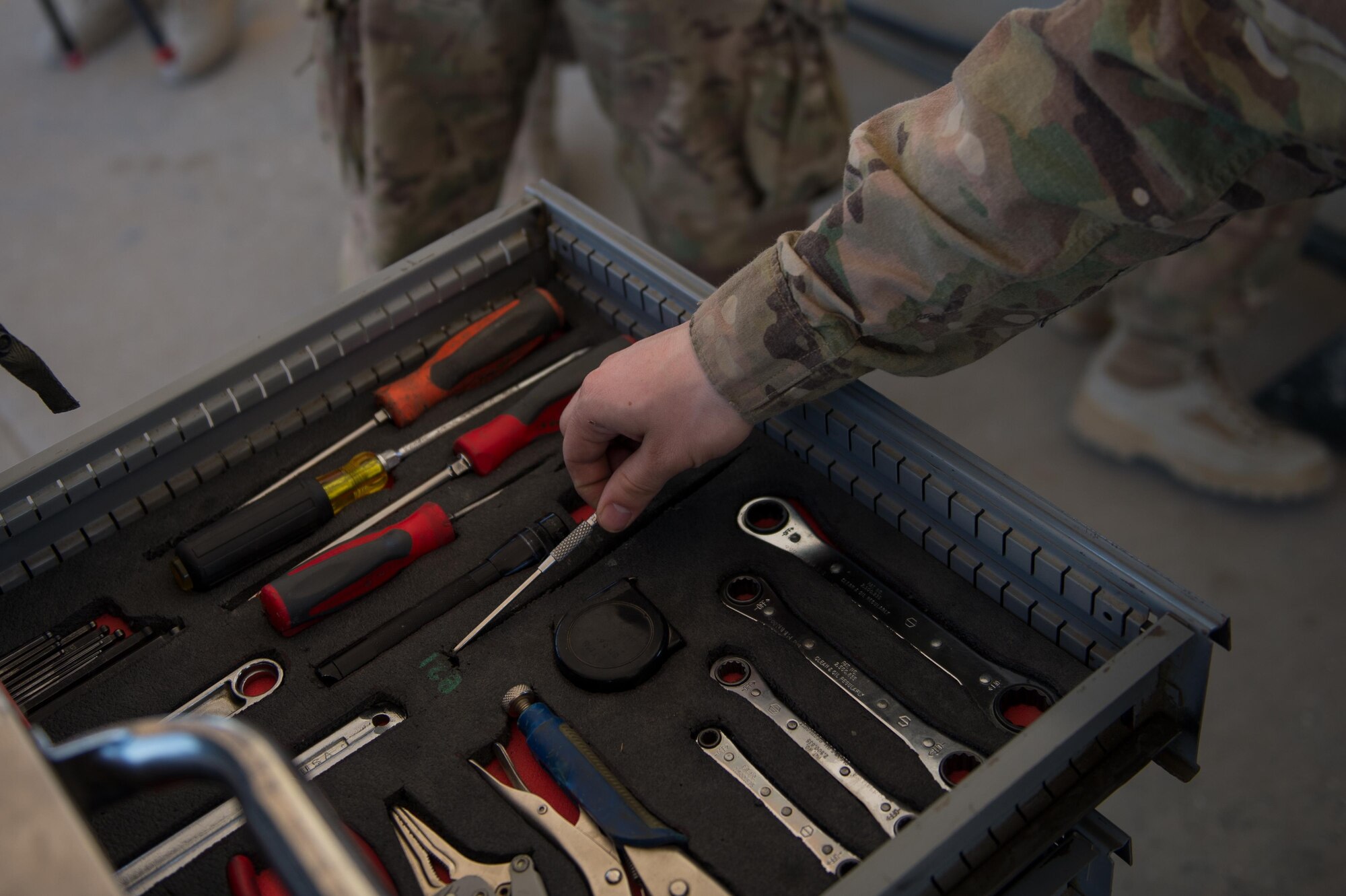 A U.S. Airman assigned to the 455th Expeditionary Maintenance Squadron Munitions Flight reaches for a tool while completing a six month inspection on a Guided Bomb Unit-54 (GBU-54) munition at Bagram Airfield, Afghanistan, June 15, 2015. The 455th EMXS Munitions Flight ensures that every munition loaded onto an F-16 Fighting Falcon will perform as expected when used. (U.S. Air Force photo by Tech. Sgt. Joseph Swafford/Released)